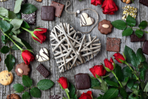 Valentinstag: Schokolade mit Rosen und Herz aus Holz in der Mitte