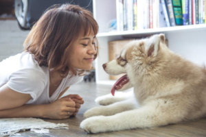 Frau liegt auf dem Boden mit Hund