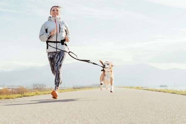 Frau macht Canicross mit Hund