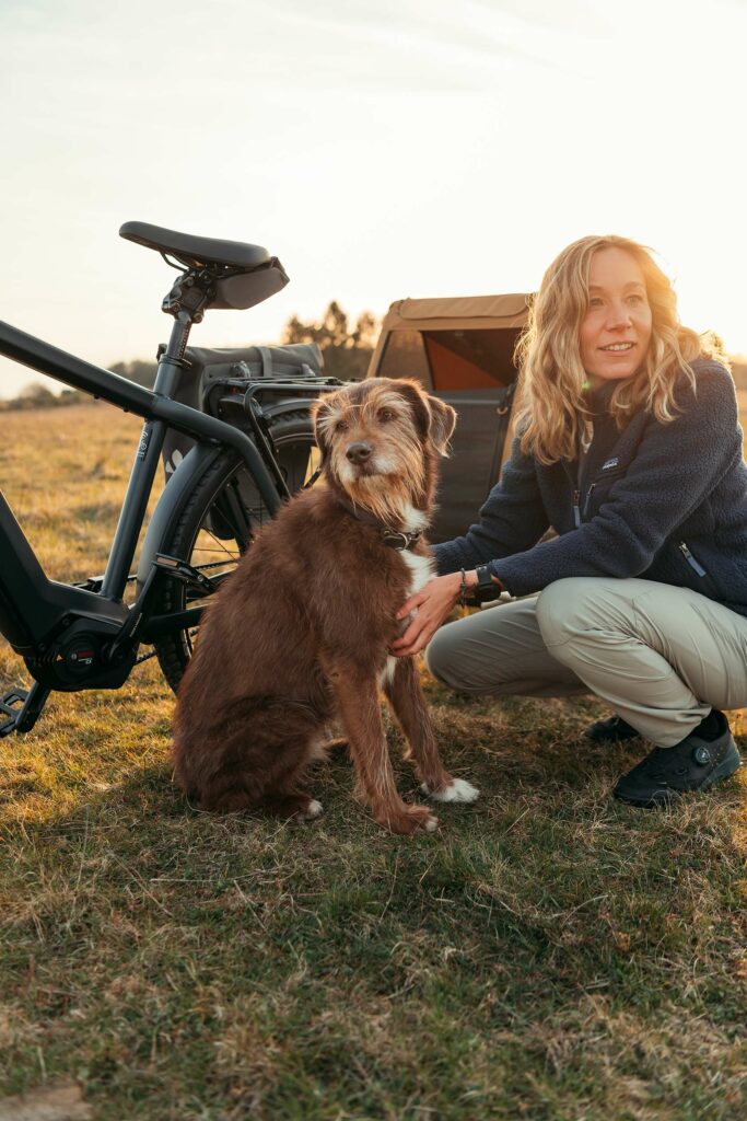 Fahrradfahren Hund: Hund mit Frau vor Fahrrad