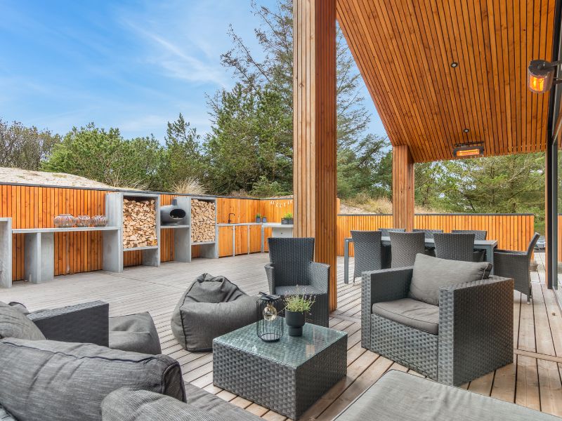 Urlaub mit Hund Dänemark - Eine Große eingezäunte Terrasse aus Holz mit verschiedenen Gartenmöbeln
